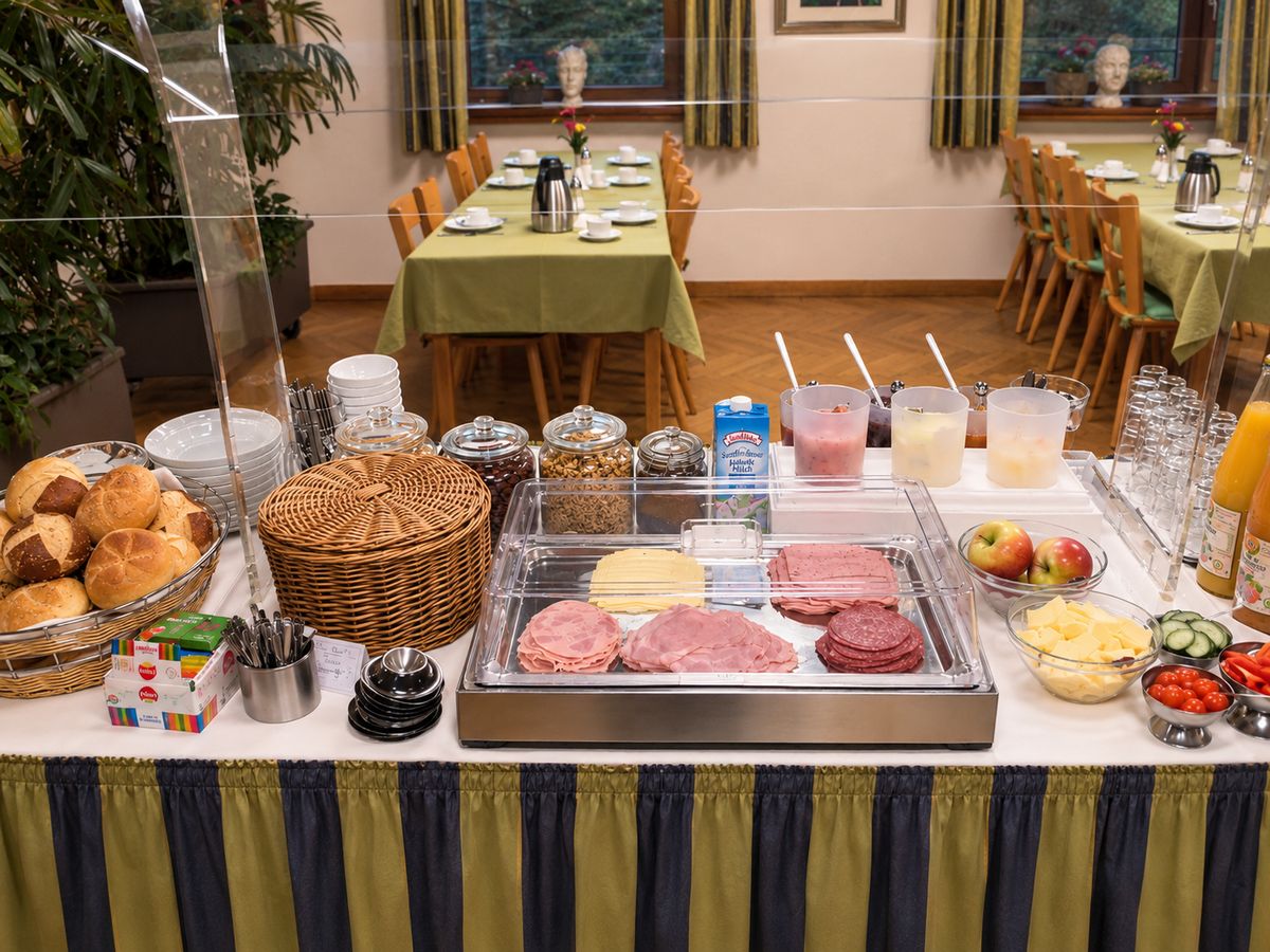 Frühstücksbuffet mit Brötchen, Aufschnitt, Käse, Obst und Müsli im Frühstücksraum des Hotels Zum Goldenen Hahnen