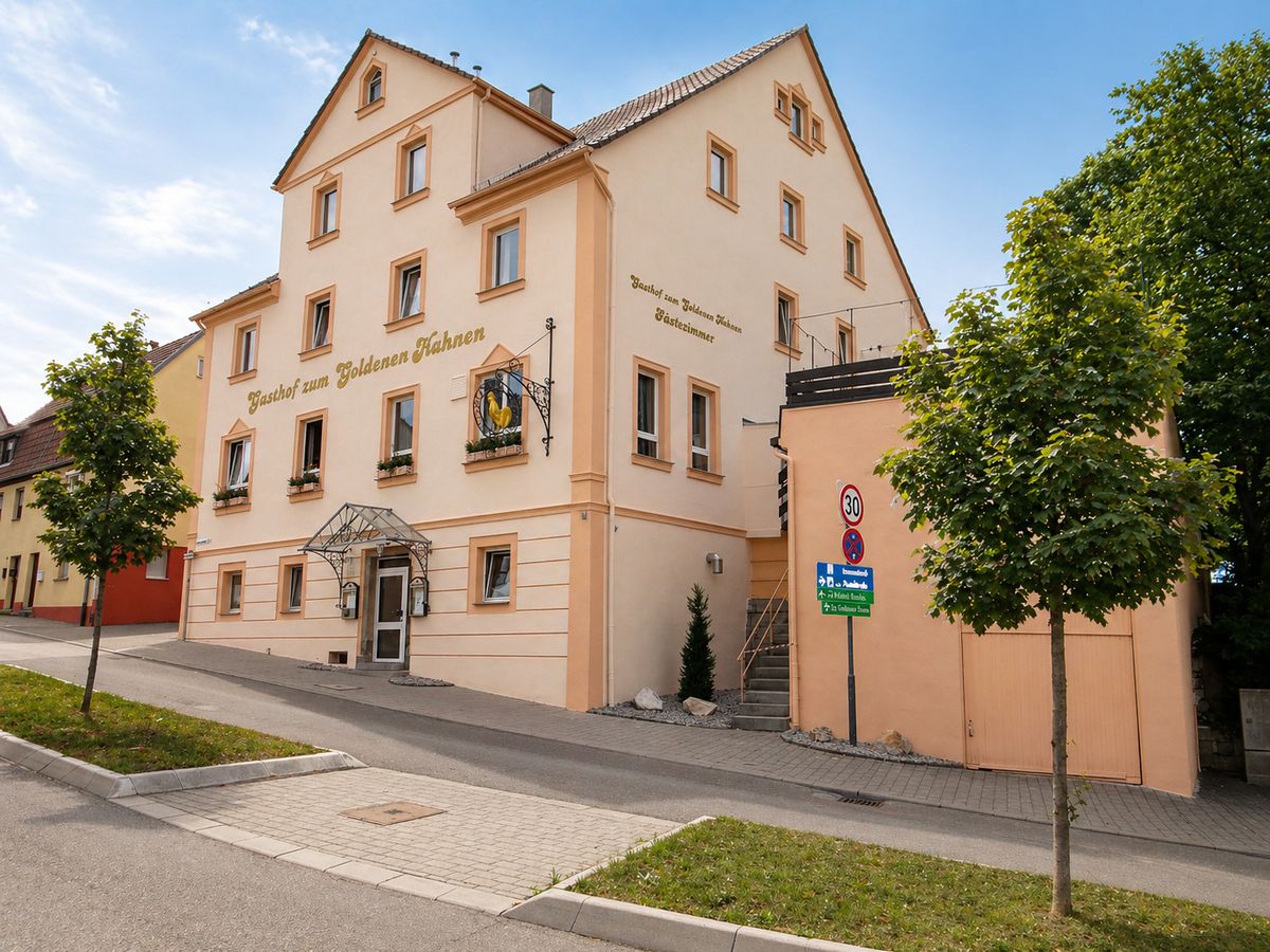 Außenansicht des Hotels Zum Goldenen Hahnen in Markgröningen, Vorderseite mit Gästezimmer-Schriftzug und Wirtshausschild