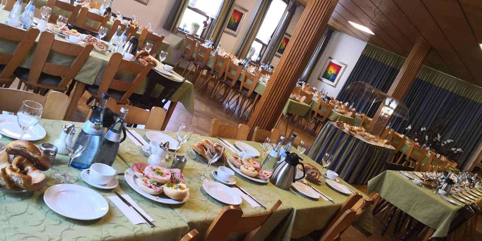 Gedeckte Kaffeetafeln im Saal mit Kaffeegedeck, belegten Brötchen, Brezeln, Hefekranz und Nusskranz für eine Trauerfeier